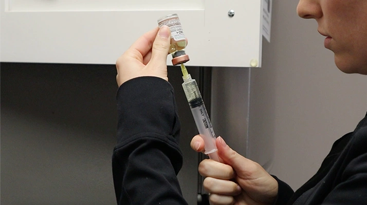 Chiropractor Towson MD filling syringe with medicine.