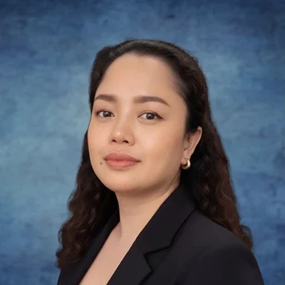 Staff Member Mae Smiling In Front Of Blue Background